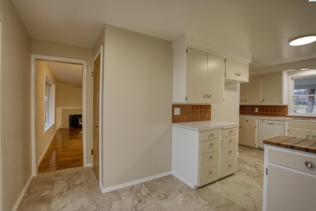 kitchen with white cabinetry, dishwasher, and backsplash