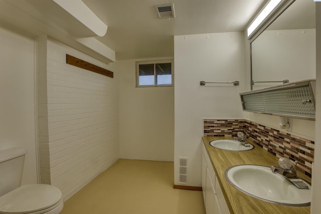 bathroom featuring tasteful backsplash, vanity, and toilet