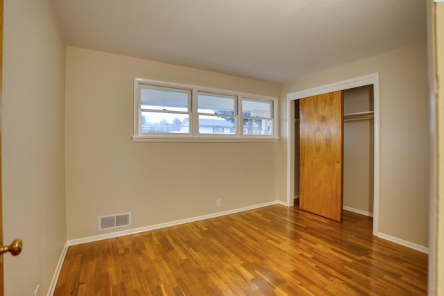 unfurnished bedroom featuring hardwood / wood-style flooring and a closet