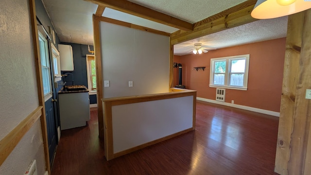 535 SE Side St, Pullman, WA 99163 - hall featuring dark wood-style flooring, a textured ceiling, beamed ceiling, a textured wall, and baseboards