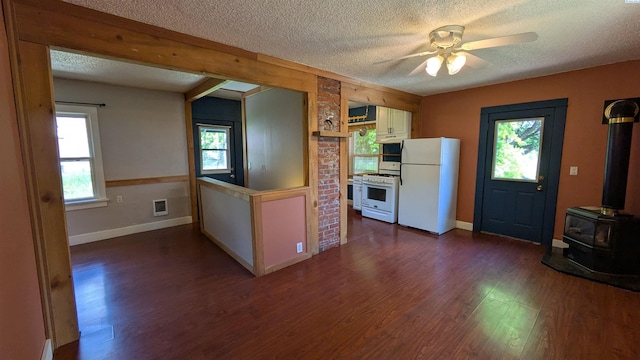 535 SE Side St, Pullman, WA 99163 - kitchen featuring white appliances, a wood stove, a textured ceiling, dark wood finished floors, and a ceiling fan