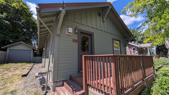 535 SE Side St, Pullman, WA 99163 - back of house featuring board and batten siding, a wooden deck, an outbuilding, and a detached garage