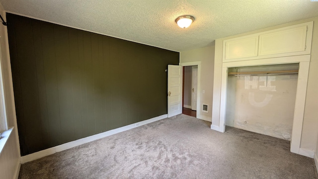 535 SE Side St, Pullman, WA 99163 - unfurnished bedroom with carpet flooring, a closet, a textured ceiling, baseboards, and wood walls