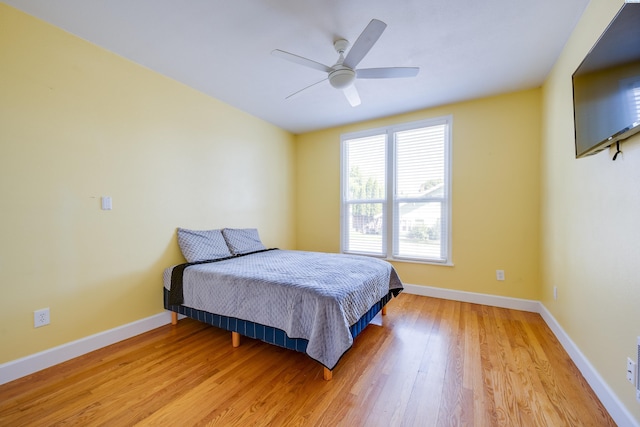 bedroom featuring light wood-type flooring, baseboards, and a ceiling fan