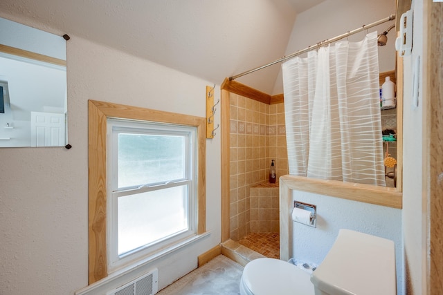 full bath featuring a stall shower, a textured wall, and toilet