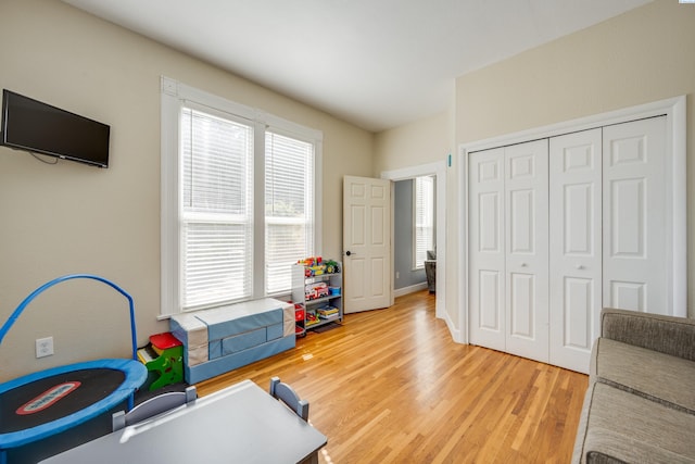 workout area with baseboards and wood finished floors