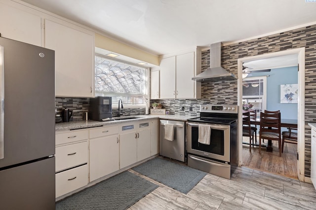 1907 Howell Ave, Richland, WA 99353 - kitchen featuring light countertops, stainless steel appliances, a sink, white cabinets, and wall chimney exhaust hood