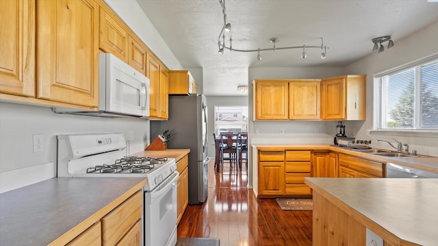 9907 Chelan Ct, Pasco, WA 99301 - kitchen featuring white appliances, dark wood-style floors, light brown cabinets, and light countertops