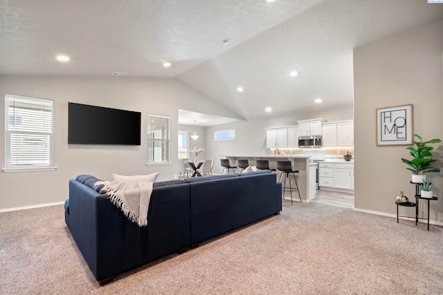 living room with light colored carpet and vaulted ceiling