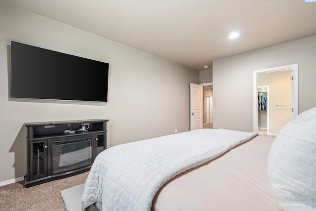 carpeted bedroom featuring a walk in closet