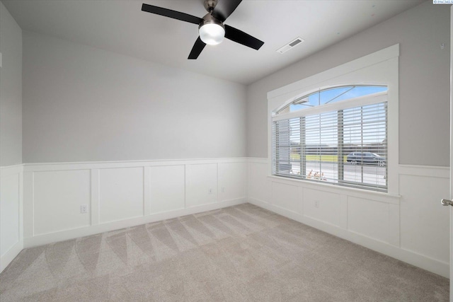 carpeted spare room featuring ceiling fan