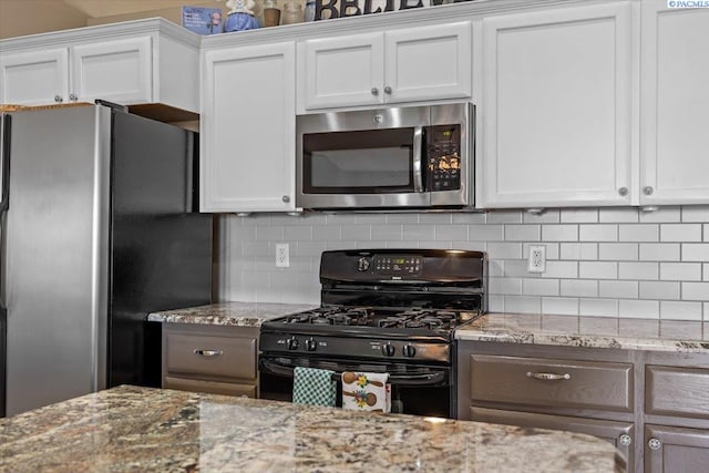 8602 W 1st Ave, Kennewick, WA 99336 - kitchen featuring stainless steel appliances, backsplash, white cabinets, and light stone countertops