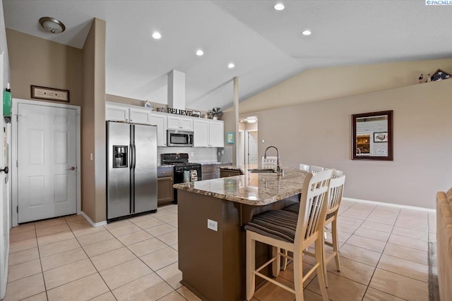 8602 W 1st Ave, Kennewick, WA 99336 - kitchen with stainless steel appliances, a sink, lofted ceiling, light tile patterned floors, and a kitchen breakfast bar