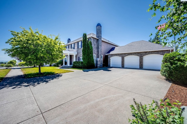 1105 SW Meyer Dr, Pullman, WA 99163 - view of front of home featuring driveway, a garage, a balcony, a front lawn, and stone siding
