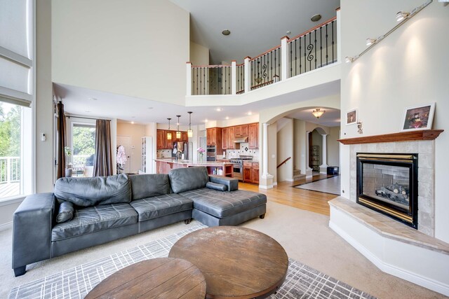 1105 SW Meyer Dr, Pullman, WA 99163 - living area with arched walkways, light colored carpet, a tiled fireplace, and a towering ceiling