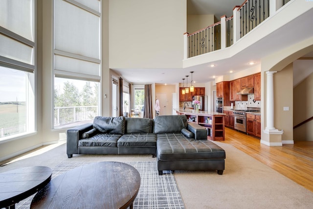 1105 SW Meyer Dr, Pullman, WA 99163 - living room with ornate columns, arched walkways, a towering ceiling, light wood-style floors, and recessed lighting
