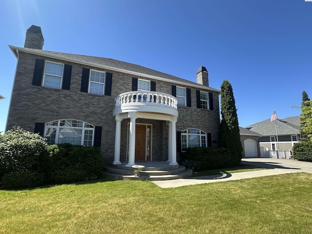 1105 SW Meyer Dr, Pullman, WA 99163 - colonial home featuring a chimney, a front lawn, driveway, and brick siding