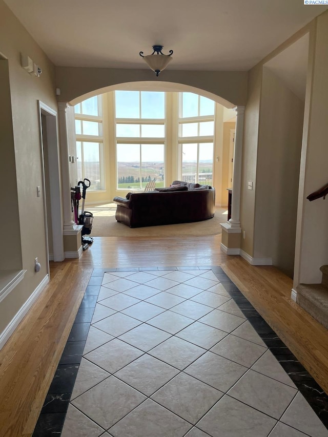 1105 SW Meyer Dr, Pullman, WA 99163 - living room featuring light tile patterned floors, ornate columns, arched walkways, baseboards, and stairs
