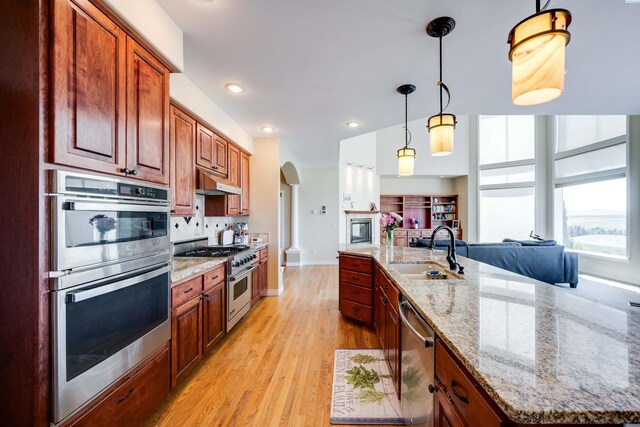 1105 SW Meyer Dr, Pullman, WA 99163 - kitchen with stainless steel appliances, arched walkways, open floor plan, decorative backsplash, and decorative light fixtures