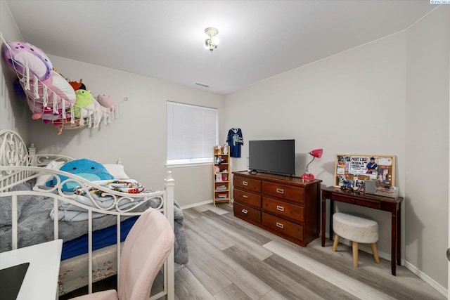 bedroom with baseboards, visible vents, and light wood-style flooring