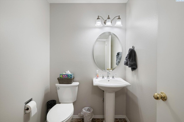 bathroom featuring toilet and baseboards