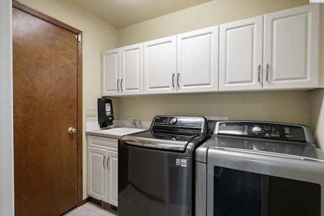 laundry room featuring a sink, cabinet space, light tile patterned flooring, and washing machine and dryer