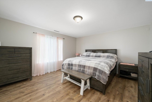 bedroom featuring visible vents and wood finished floors
