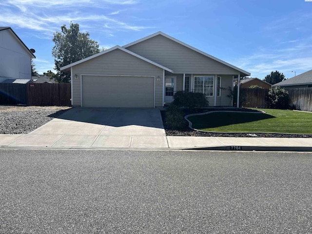 ranch-style home featuring a garage, concrete driveway, a front yard, and fence