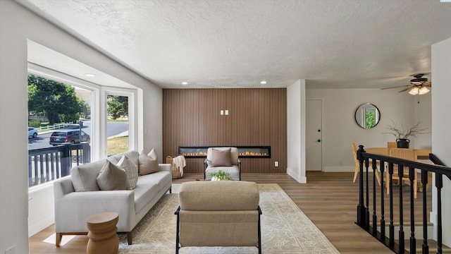 4308 S Sharron Ct, Kennewick, WA 99337 - living area with a glass covered fireplace, wood finished floors, a textured ceiling, recessed lighting, and a ceiling fan