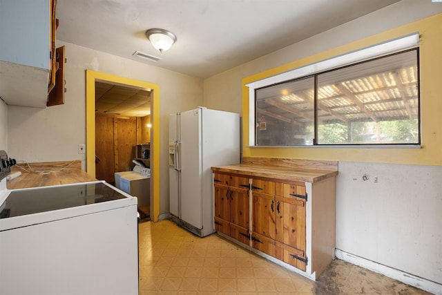 2018 W 2nd Ave, Kennewick, WA 99301 - kitchen with stove, white refrigerator with ice dispenser, light floors, and brown cabinetry