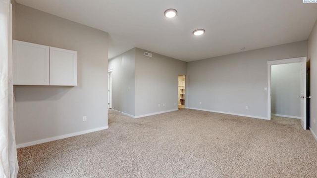 unfurnished room featuring visible vents, light carpet, and baseboards