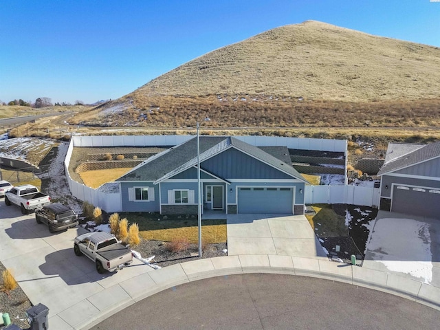 view of front of house featuring concrete driveway, an attached garage, fence, and board and batten siding