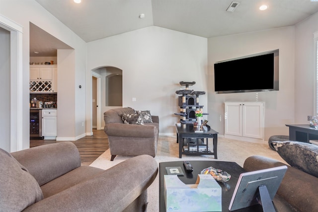 living room with visible vents, wine cooler, recessed lighting, arched walkways, and a bar