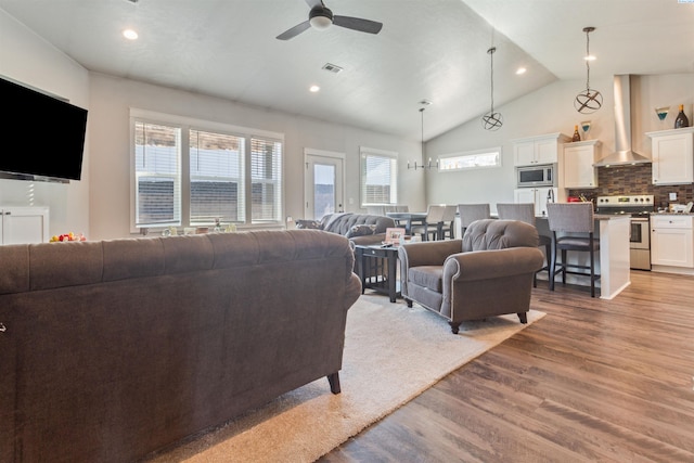 living area with visible vents, recessed lighting, wood finished floors, high vaulted ceiling, and a ceiling fan