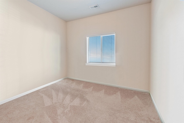 carpeted spare room featuring baseboards and visible vents