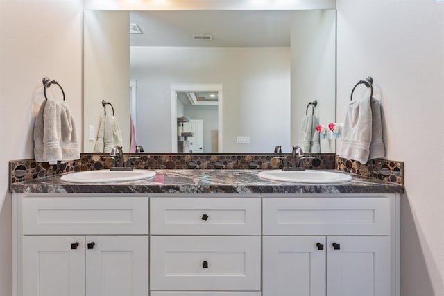 full bath featuring double vanity, visible vents, and a sink