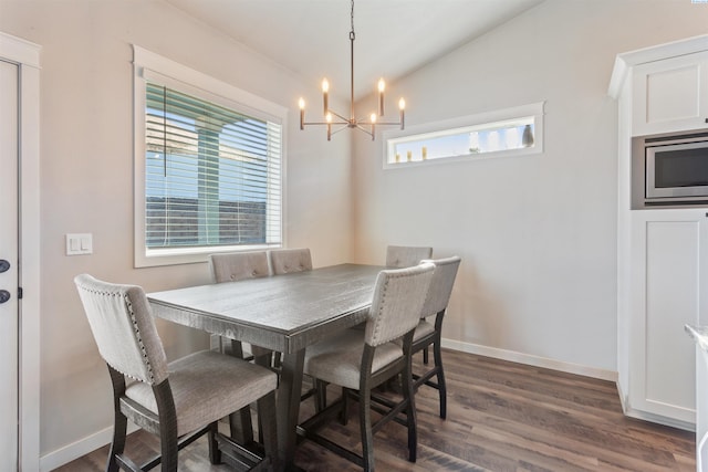 dining space with dark wood-style floors, lofted ceiling, a healthy amount of sunlight, and a chandelier