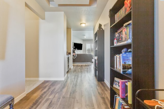 corridor featuring baseboards and wood finished floors