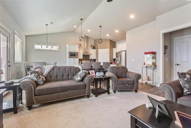 living area with recessed lighting, light colored carpet, and vaulted ceiling