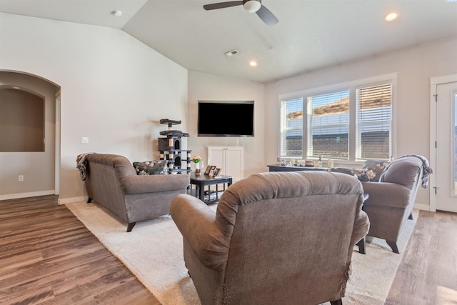 living room with visible vents, lofted ceiling, arched walkways, and wood finished floors