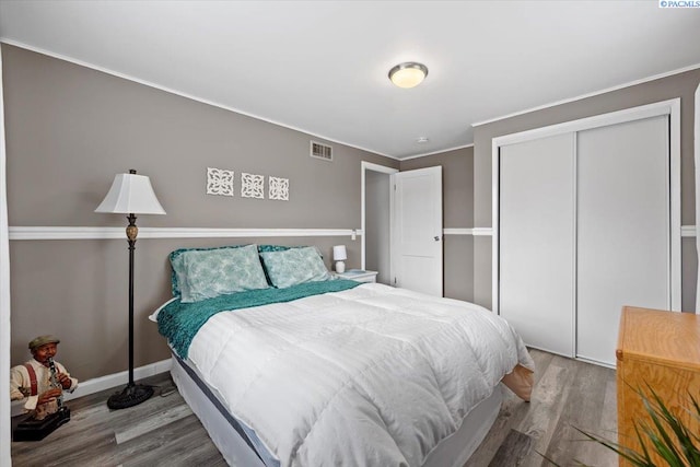 bedroom with wood-type flooring and a closet