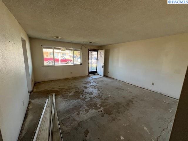 empty room featuring unfinished concrete flooring and a textured ceiling