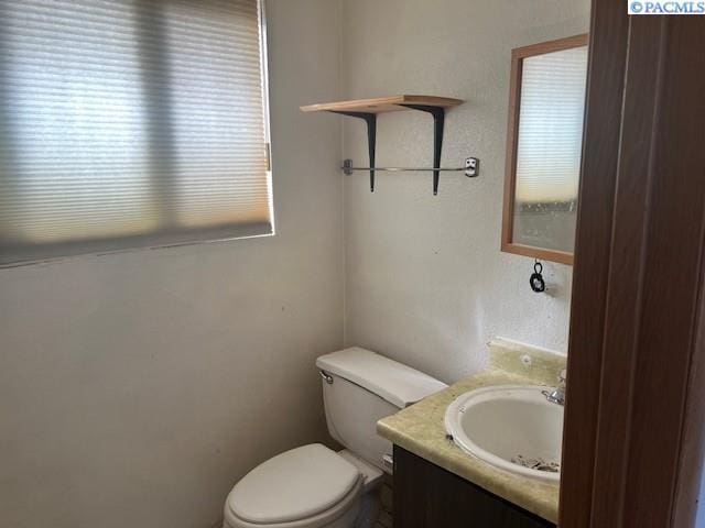 bathroom with a healthy amount of sunlight, vanity, and toilet