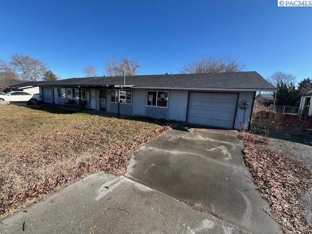 single story home featuring concrete driveway, a front lawn, and an attached garage