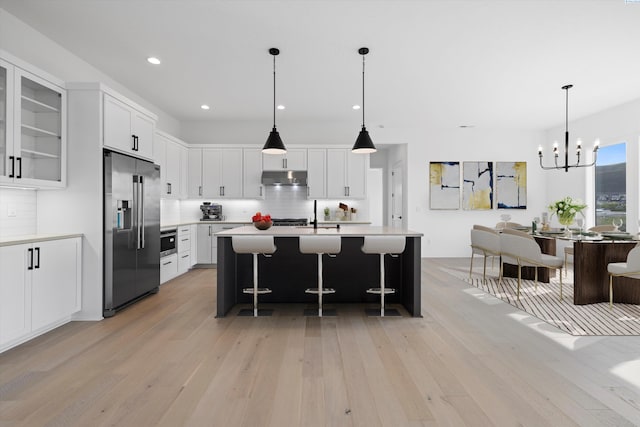 kitchen featuring tasteful backsplash, high end fridge, and white cabinets