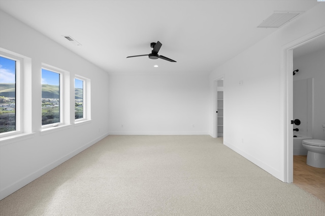 unfurnished room with ceiling fan and light carpet