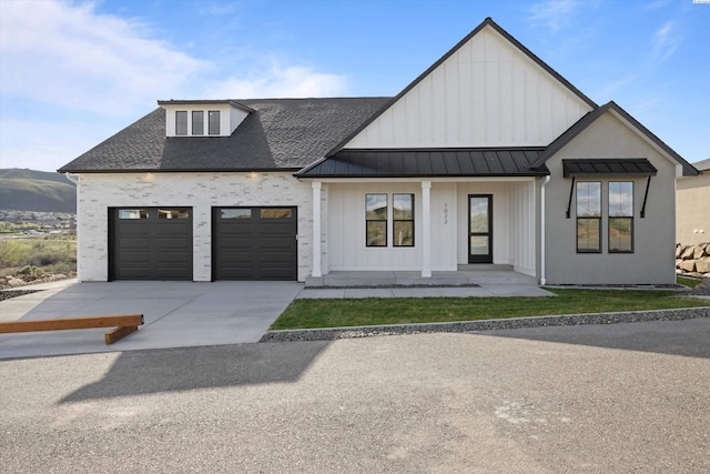 modern farmhouse style home featuring a garage, a mountain view, and a porch