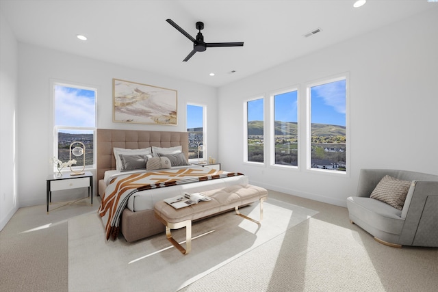 bedroom with light carpet, a mountain view, and ceiling fan