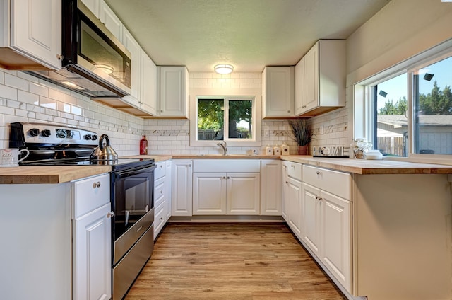 kitchen featuring stainless steel appliances, sink, light wood-type flooring, and white cabinets