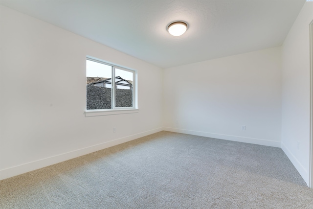 carpeted spare room with baseboards
